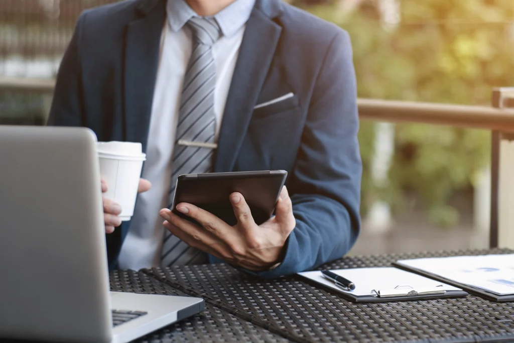 executive in a suit with a laptop and coffee